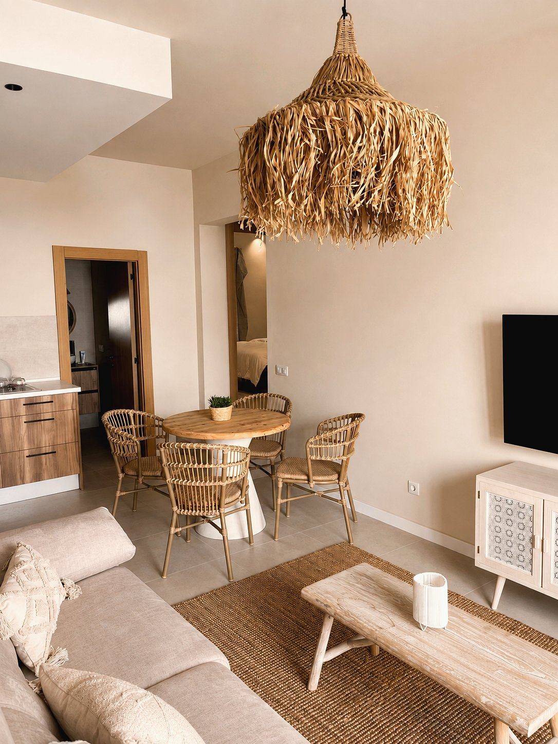Salón con mesa de ratón, lámpara de rafia y sofá beige de Casa Nido